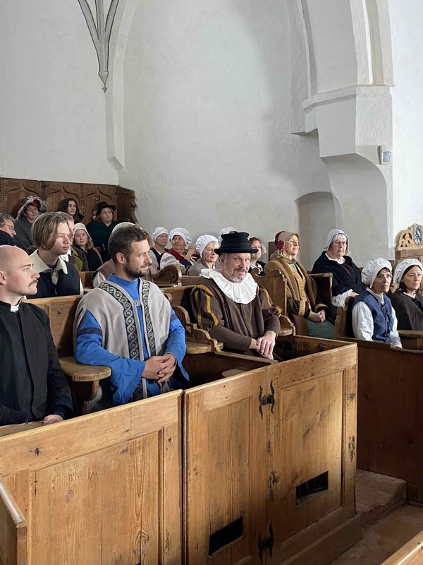 In der St. Martinskirche in Memmingen spielen Laienschauspieler:innen und Mitglieder aus Heimatvereinen als Statist:innen eine Szene mit dem Prediger Christoph Schappeler. Foto: Karl Milz