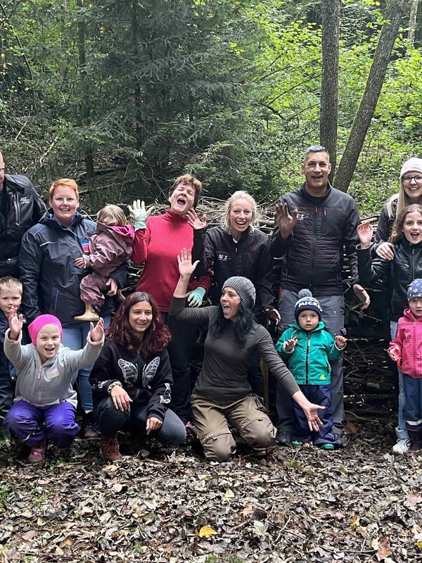 Das Werk ist vollbracht! Kinder und Erwachsene freuen sich über die Totholzhecke, die sie gemeinsam im Bachspielwald in Hohenweiler errichtet haben.